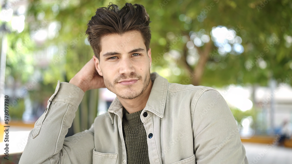 Young hispanic man standing with serious expression at park Young hispanic man standing with serious expression at park