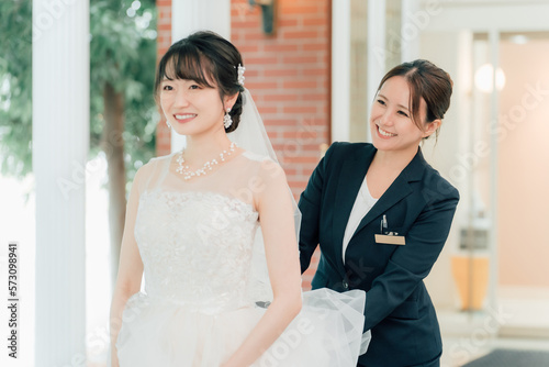 結婚式場を案内するウェディングプランナー・ブライダルアテンダー・介添人の女性と花嫁・新婦（結婚式） 