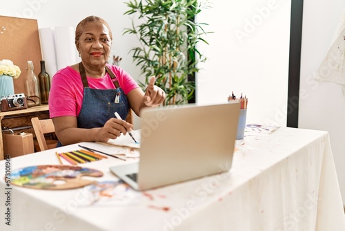 Senior african american woman having online draw class at art studio