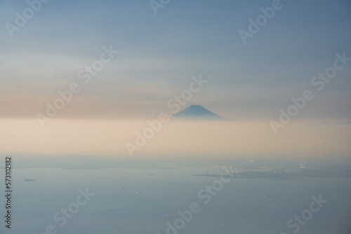 Tokyo, Japan - February 17, 2023: Aerial view of hazy Mt. Fuji over clouds 