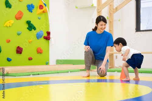 室内で運動をする子供たちと先生 広角 コピースペースあり