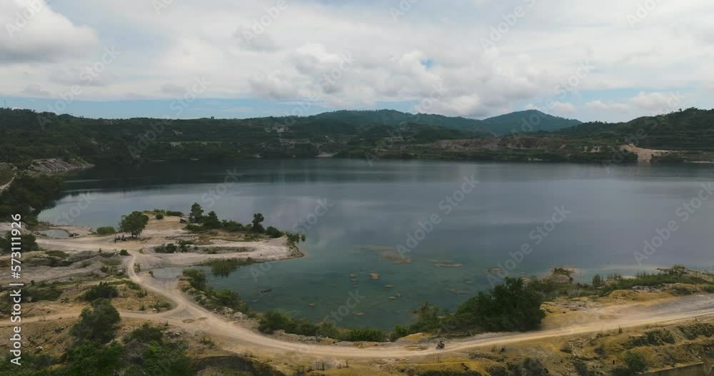 Mining quarry with flooded bottom. Lake with blue water near sand pit. Sipalay, Negros, Philippines.