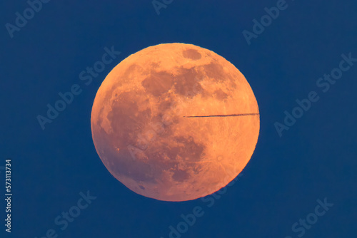 Quadro su tela A jet and its contrail crosses the full moon on the night of the blood moon total eclipse
