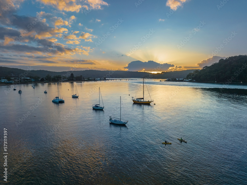 Sunrise over the water with clouds and boats Sunrise over the water with clouds and boats
