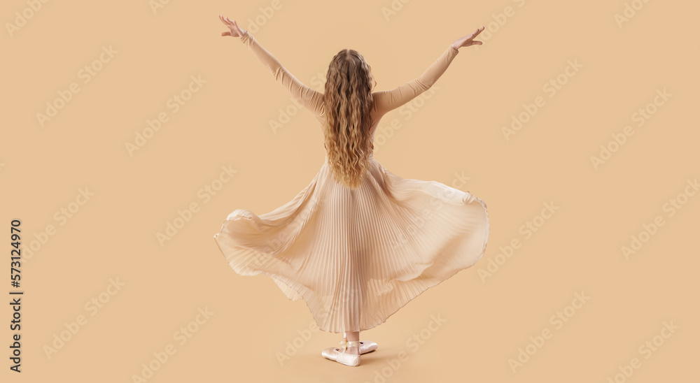 Fototapeta premium Dancing young ballerina on beige background, back view