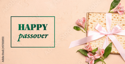 Greeting card for Passover with Jewish flatbread matza and flowers on beige background photo