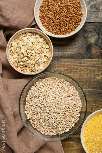 Bowls with cereals on wooden background, closeup