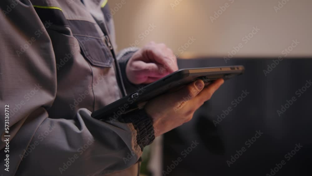 Close up shot of installer sets up security camera in house using digital tablet computer and app. Worker checks internet speed after installation. Installation of wireless local area network. WLAN.
