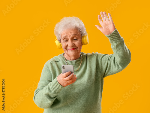 Senior woman in headphones ...