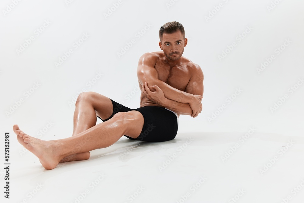Obraz premium Man athletic body bodybuilder in briefs with naked torso abs full-length in the background, fitness classes. Advertising, sports, active lifestyle, competition, challenge concept.