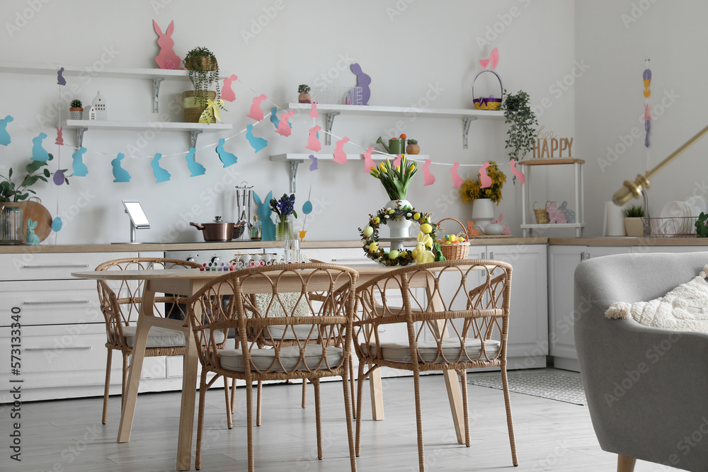 Interior of kitchen decorated for Easter celebration with wreath and dining table