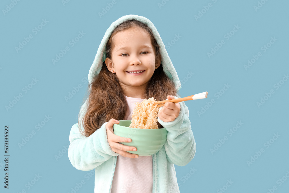 Little girl with bowl of Chinese noodles on blue background Little girl with bowl of Chinese noodles on blue background