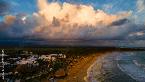 aerial drone image of beautiful beach during sunset in Punta Cana. the golden sunset feels the sky with crimson orange and crystal clear water 