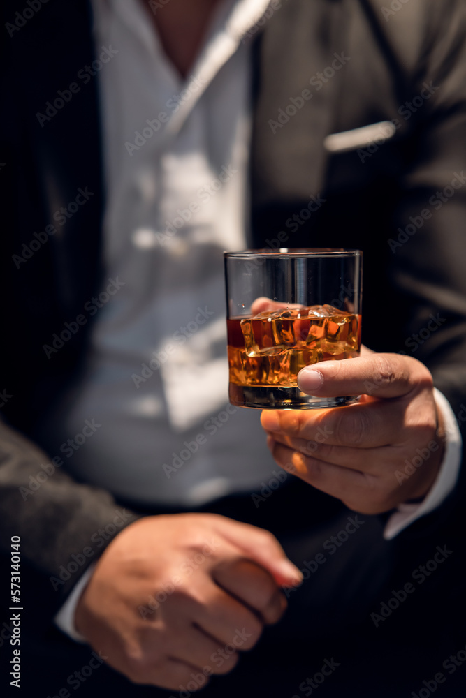 Businessman sitting and holding glass of whiskey