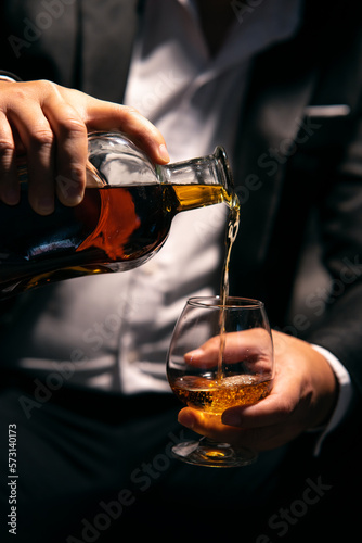 Businessman sitting and holding glass of whiskey