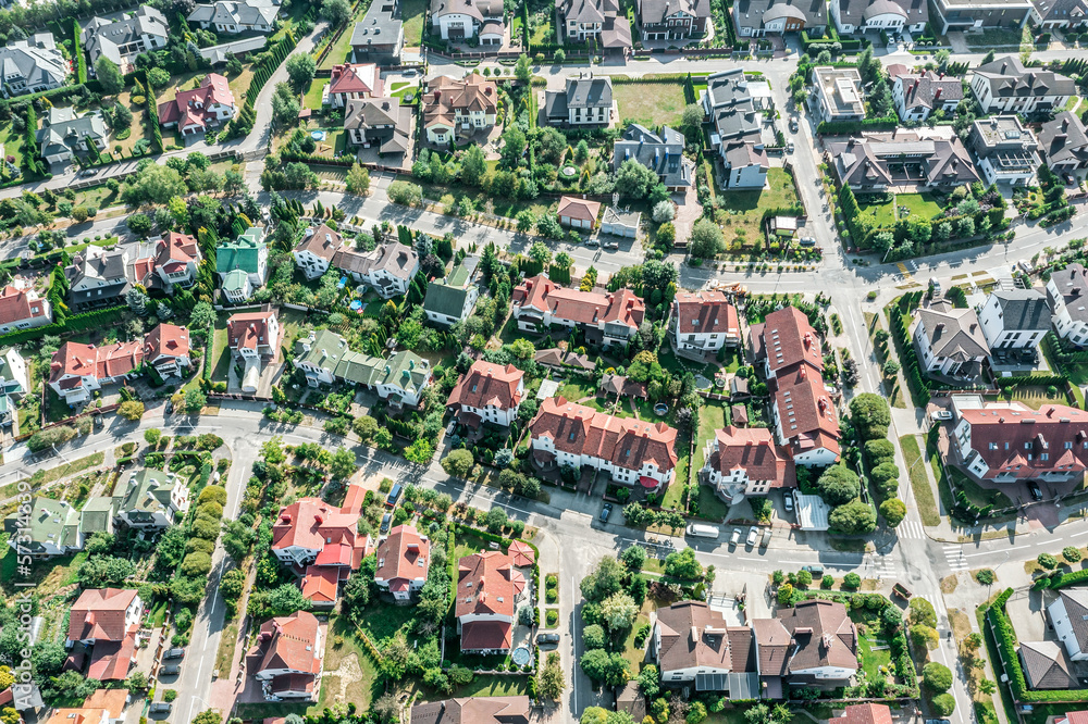 typical european housing estate on a sunny day. rows of houses, roads and green gardens. aerial