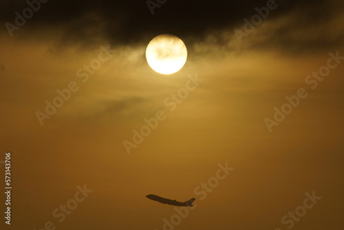Sun and flight in parallel while rising in sunrise sky