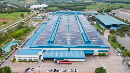 Aerial view of blue photovoltaic solar panels rooftop. Construction Solar panels or Solar cells on industrial factory rooftop. Production of sustainable energy or green ecological electricity concept.