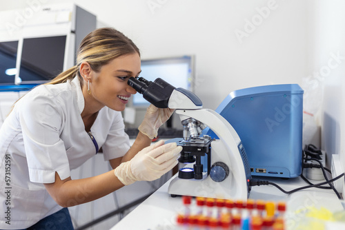 Scientist biochemist or microbiologist working research with a microscope in laboratory. photo