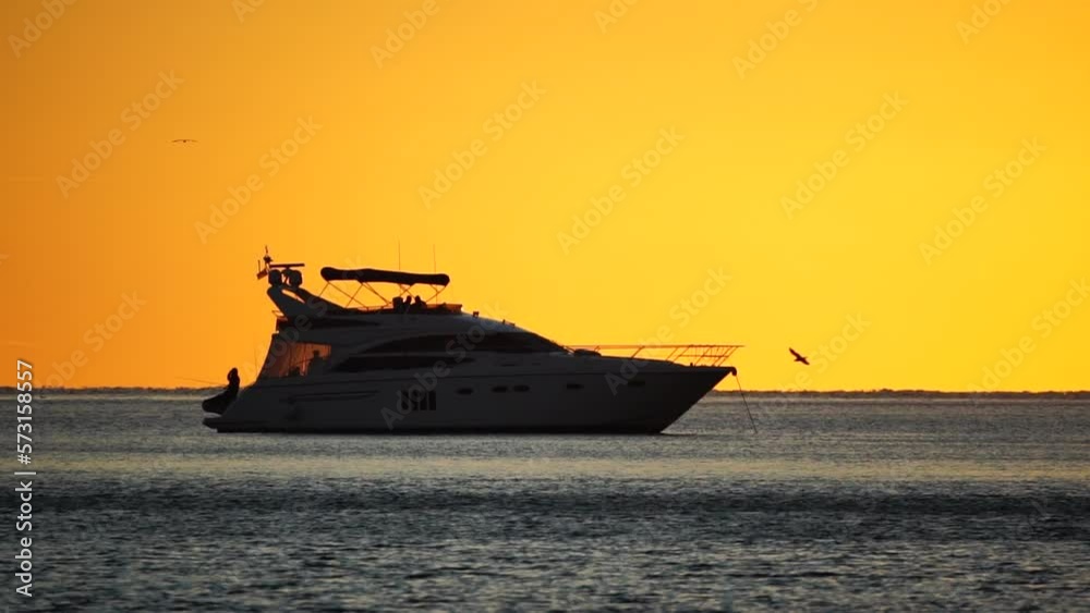 Luxury cruise trip. Red burning sunset over the sea with silhouette of rich yacht. Abstract nature summer ocean sea background. Summer journey on luxury ship Luxury cruise trip. Red burning sunset over the sea with silhouette of rich yacht. Abstract nature summer ocean sea background. Summer journey on luxury ship
