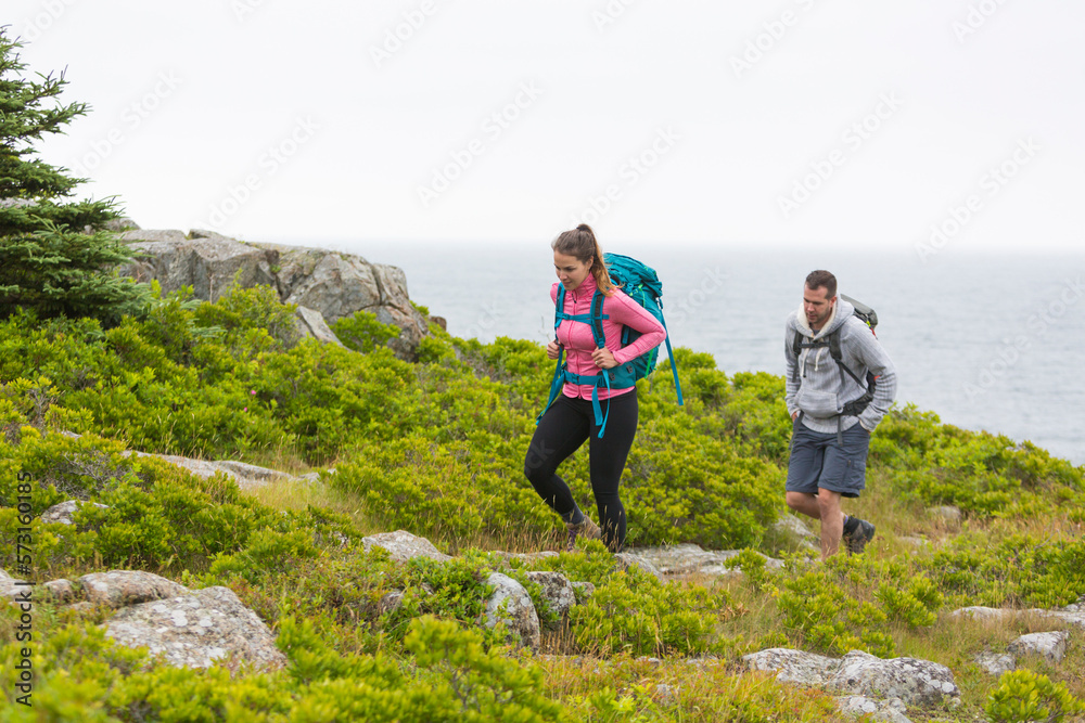 Man and woman walking on green cliffs during daytime, Acadia National Park, Maine, USA Man and woman walking on green cliffs during daytime, Acadia National Park, Maine, USA