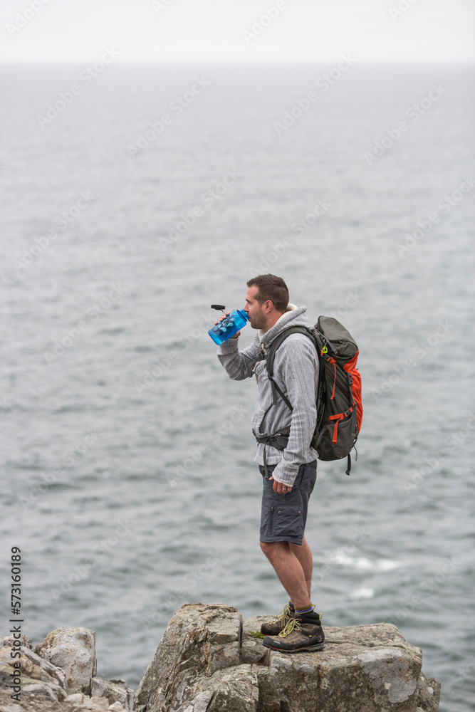 Hiker standing on rock by sea in Acadia National Park, Maine, USA Hiker standing on rock by sea in Acadia National Park, Maine, USA