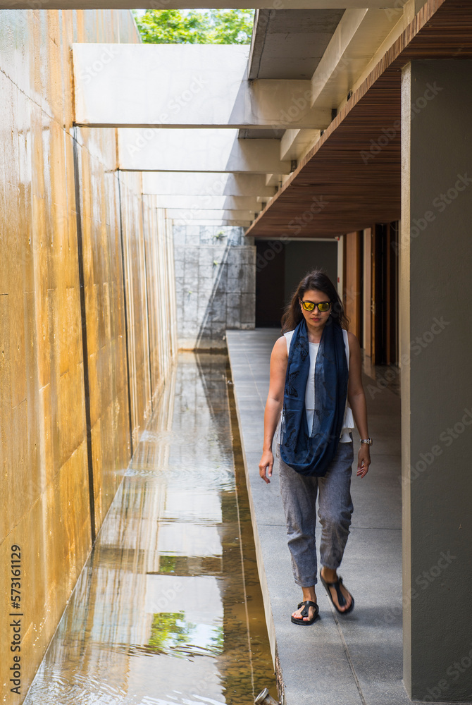 Woman walking next to artificial waterfall, Chiang Mai, Thailand Woman walking next to artificial waterfall, Chiang Mai, Thailand