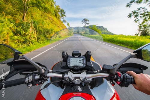 Personal perspective of biker riding on empty countryside highway,Â ChiangÂ Rai,Â MueangÂ Chiang Rai District, Thailand photo