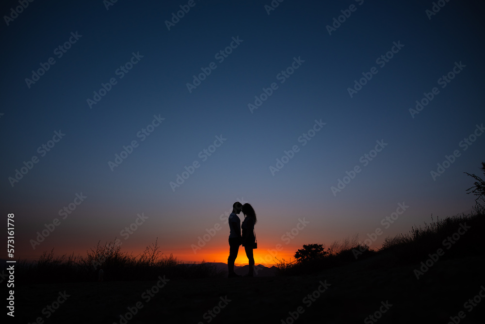 Young couple enjoying sunset in the mountains Young couple enjoying sunset in the mountains