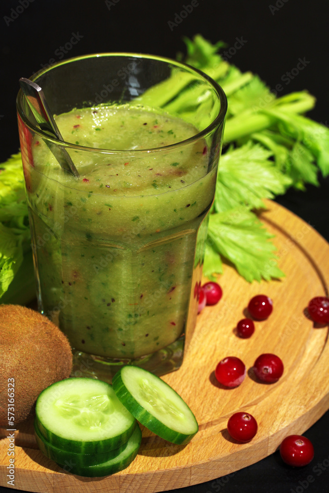 Fototapeta premium green smoothie in a glass of raw vegetables, fruits and berries close-up.