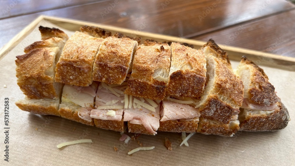 Jambon-beurre closeup on the table. A jambon-beurre is a French ham sandwich made of a fresh baguette sliced open, spread with salty butter, and filled with slices of ham. Jambon-beurre closeup on the table. A jambon-beurre is a French ham sandwich made of a fresh baguette sliced open, spread with salty butter, and filled with slices of ham.