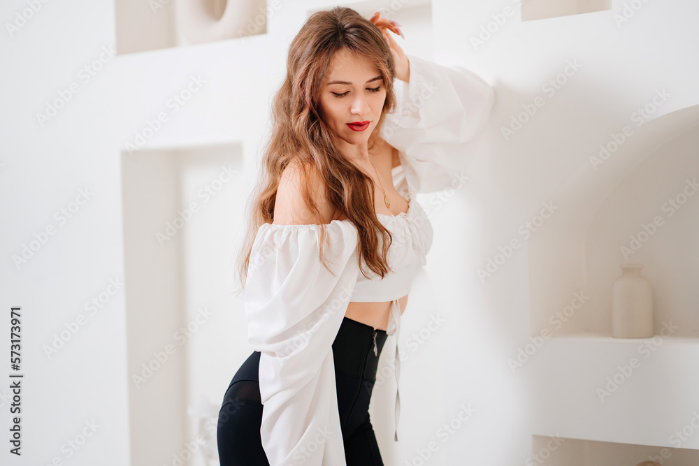 portrait of an attractive woman in a white romantic top with open shoulders. portrait of an attractive woman in a white romantic top with open shoulders.