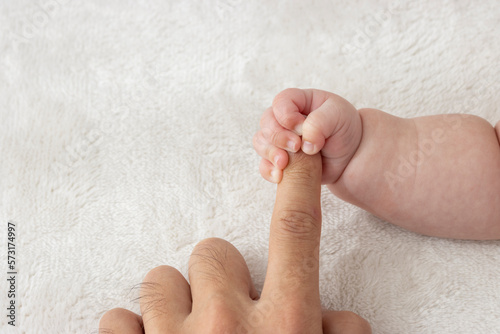 父親の指を握りしめる赤ちゃんの右手（0歳2か月、男の子、日本人）