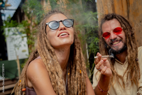 Hippie style couple smoking cigarettes with medical marijuana