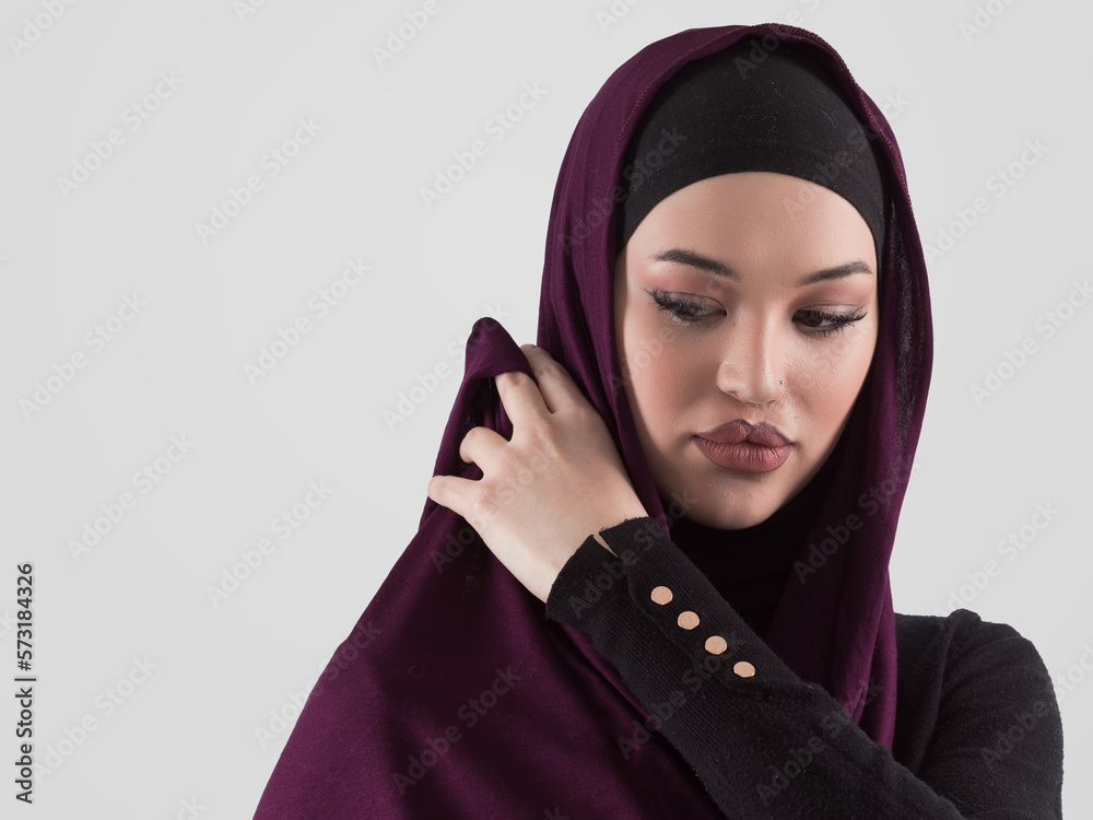 Muslim woman wearing modern stylish wear and hijab isolated on grey background. Diverse people model hijab fashion concept. Muslim woman wearing modern stylish wear and hijab isolated on grey background. Diverse people model hijab fashion concept.