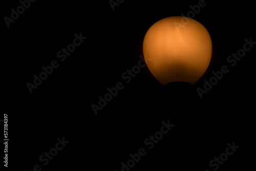 light from artistic orange lamp on black background © ATRPhoto
