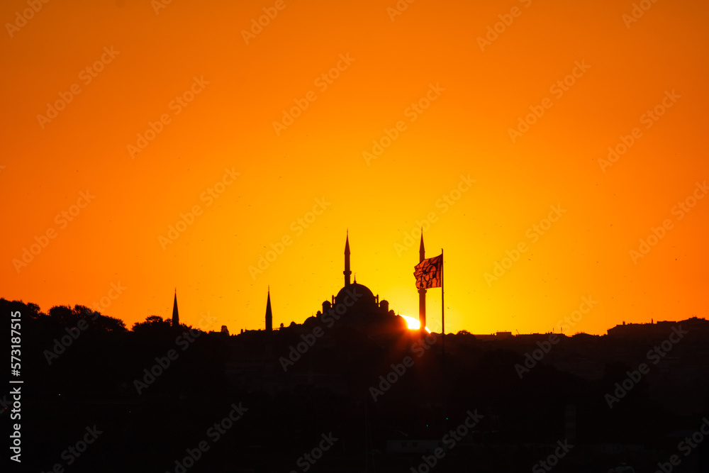 Naklejka premium Fatih Mosque silhouette at sunset with Flag of Turkiye