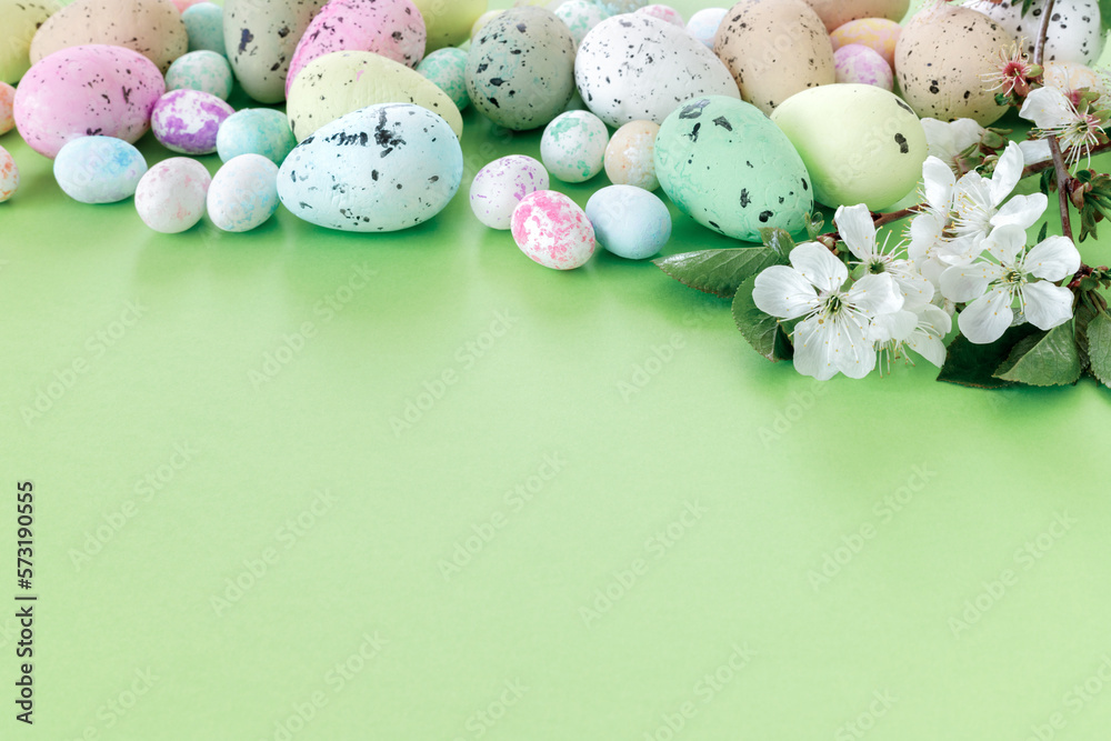 Beautiful Easter card with colorful eggs and cherry branches on paper green background.
