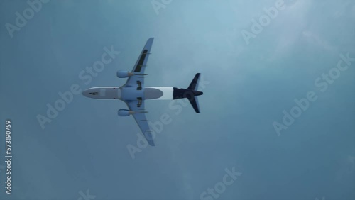 Passenger plane flying overhead. View from below of the flying plane. Video 4k