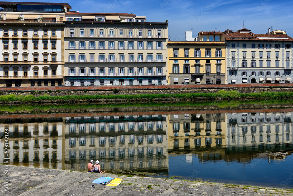 couple resting at Pescaia di Santa Rosa - Santa Rosa dam on Arno river, waterfront luxury hotels along Lungarno Amerigo Vespucci, old town, UNESCO , Florence, Tuscany, Italy, Europe