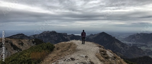 Bergwanderer (männlich) schaut in die Ferne am Gipfel des Geigelstein, Alpen, Chiemgau, Bayern, Deutschland