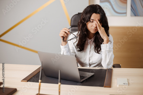 Stressed and angry young indian or arabic business woman having online meeting at the office by laptop