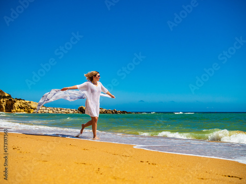 Beautiful woman walking on sunny beach 