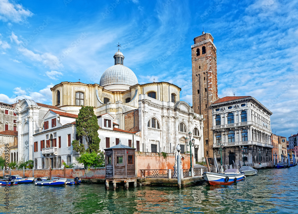 Venetian canal with boats and Santa Maria Gloriosa dei Frari Church in bright summer day, Venice