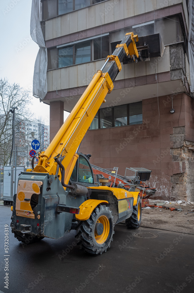 yellow Skid-steer loader, a construction machine is being loaded with construction debris through a window