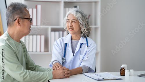 Expert Asian senior female doctor talking with her male patient show support and care.