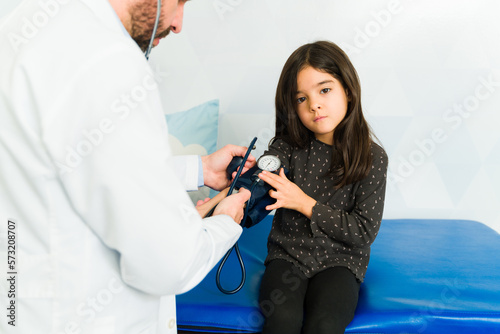 Sick young kid getting a medical check-up with a pediatrician