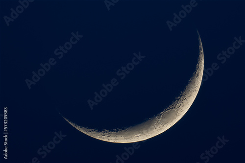 A thin crescent moon on a dark blue background photo