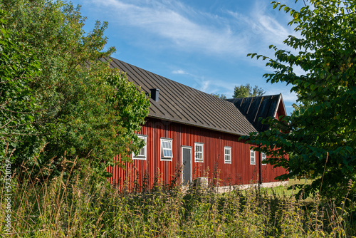 Traditional ancient old vintage red Swedish house from wood on a sunny day in summer. Stylish European private house.