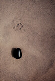 Approximation of black stone on the sand, a top view Generative AI